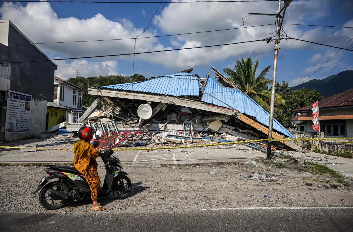 A motorbike stops next to a collapsed building following a 7.7-magnitude earthquake in Borong, East Manggarai, East Nusa Tenggara on Aug 16, 2026. Help started arriving on Aug 16 for thousands of evacuees on Indonesia's Flores island after a powerful earthquake killed over 50 people, injured dozens and damaged hundreds of houses and buildings. - Photo: AFP