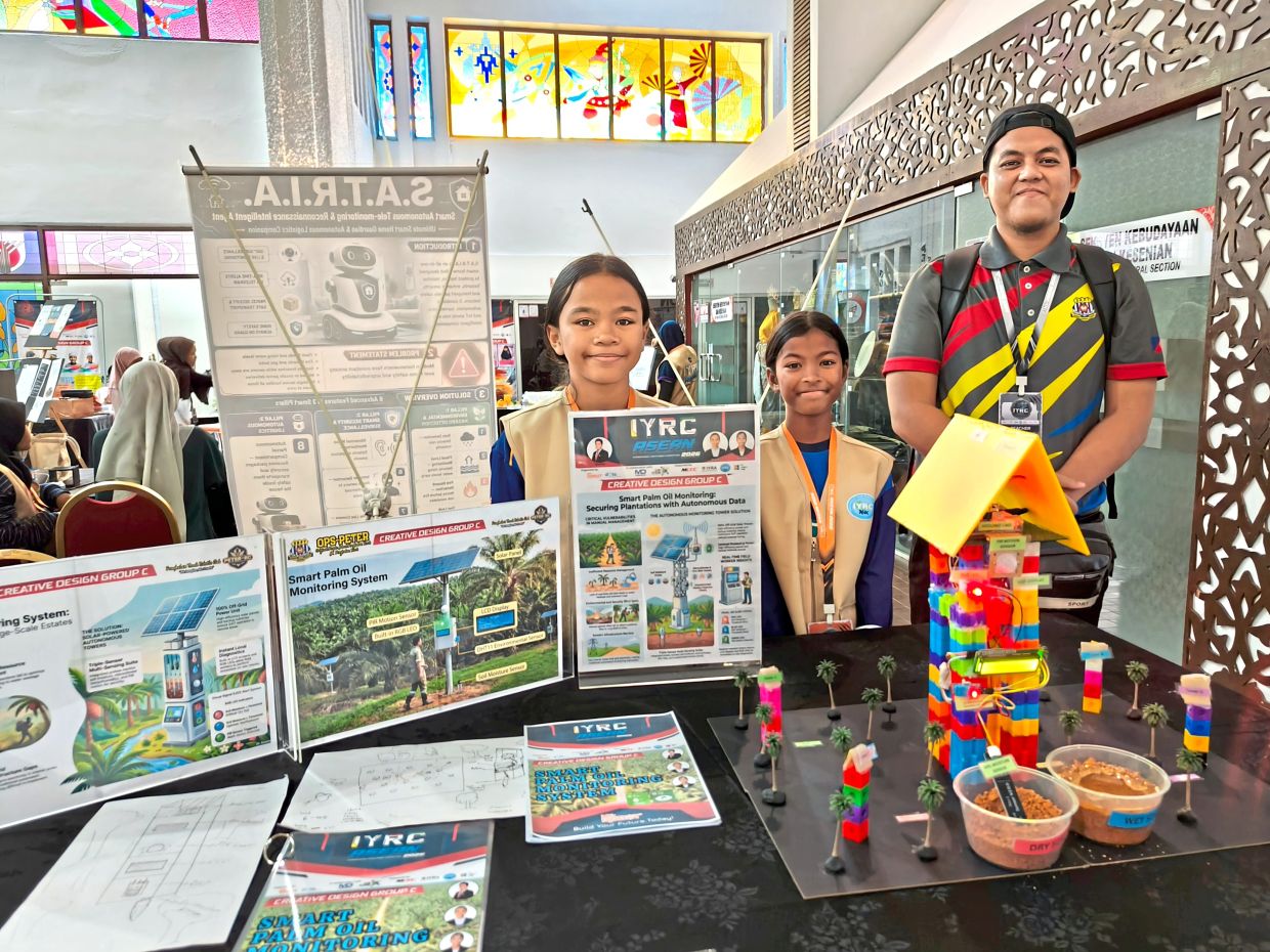 Che Muhammad Fakhri (right) with his students Qaseh (left) and Nikisha with their Smart Palm Oil Monitoring System at the Creative Design exhibition. — ANGELIN YEOH/The Star