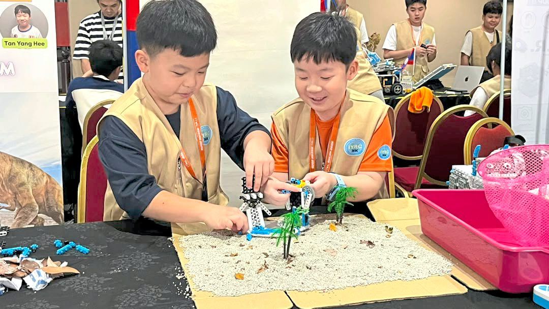Wong (left) and Tan preparing for their presentation at IYRC 2026. — My-Robot Medini