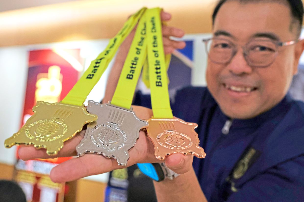 Cheah showing off medals for the 20th Battle of the Chefs.