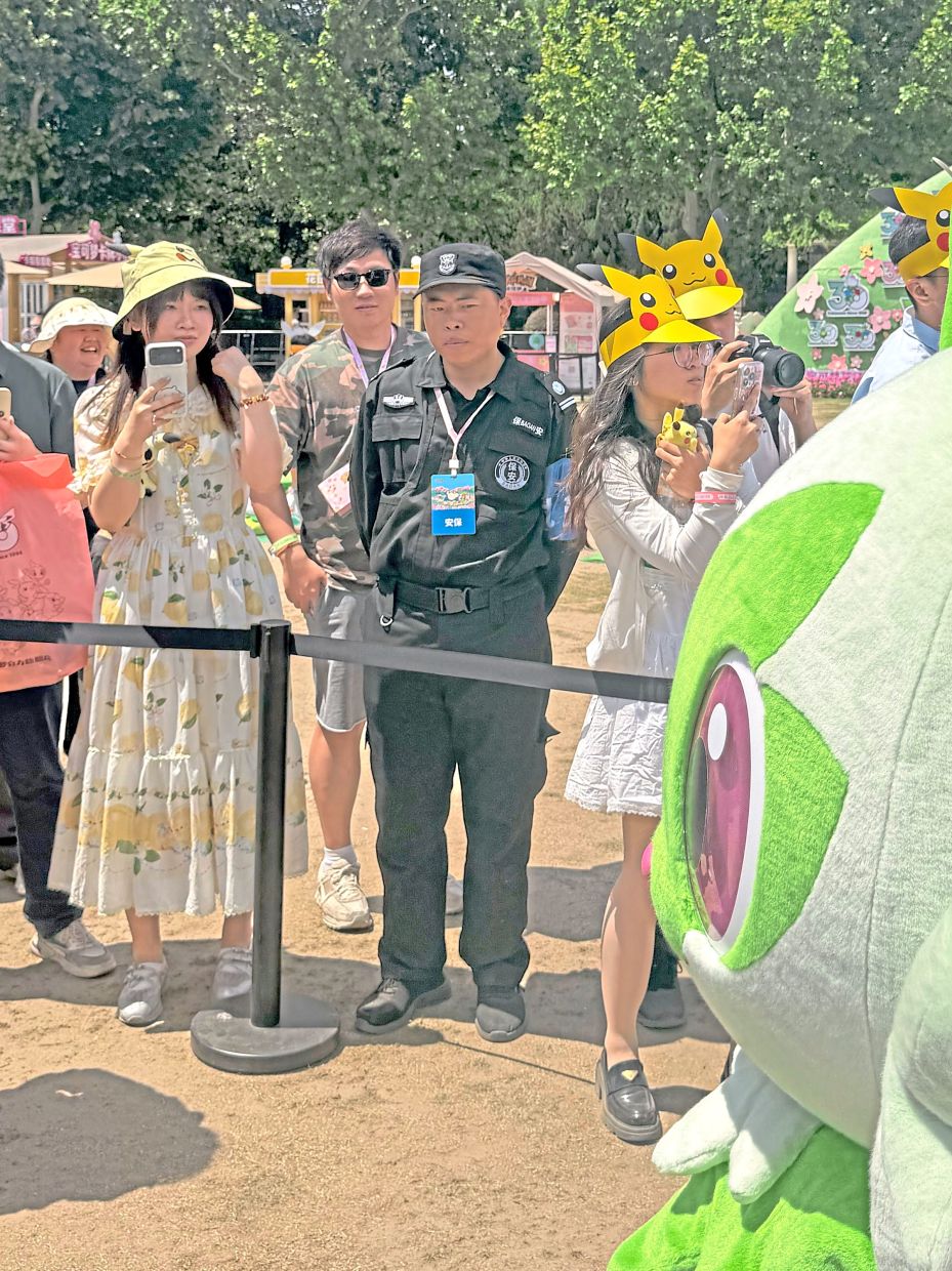 Hu working as a security guard for a Pokemon festival in Shanghai in May this year.— Vivian Wang/The New York Times