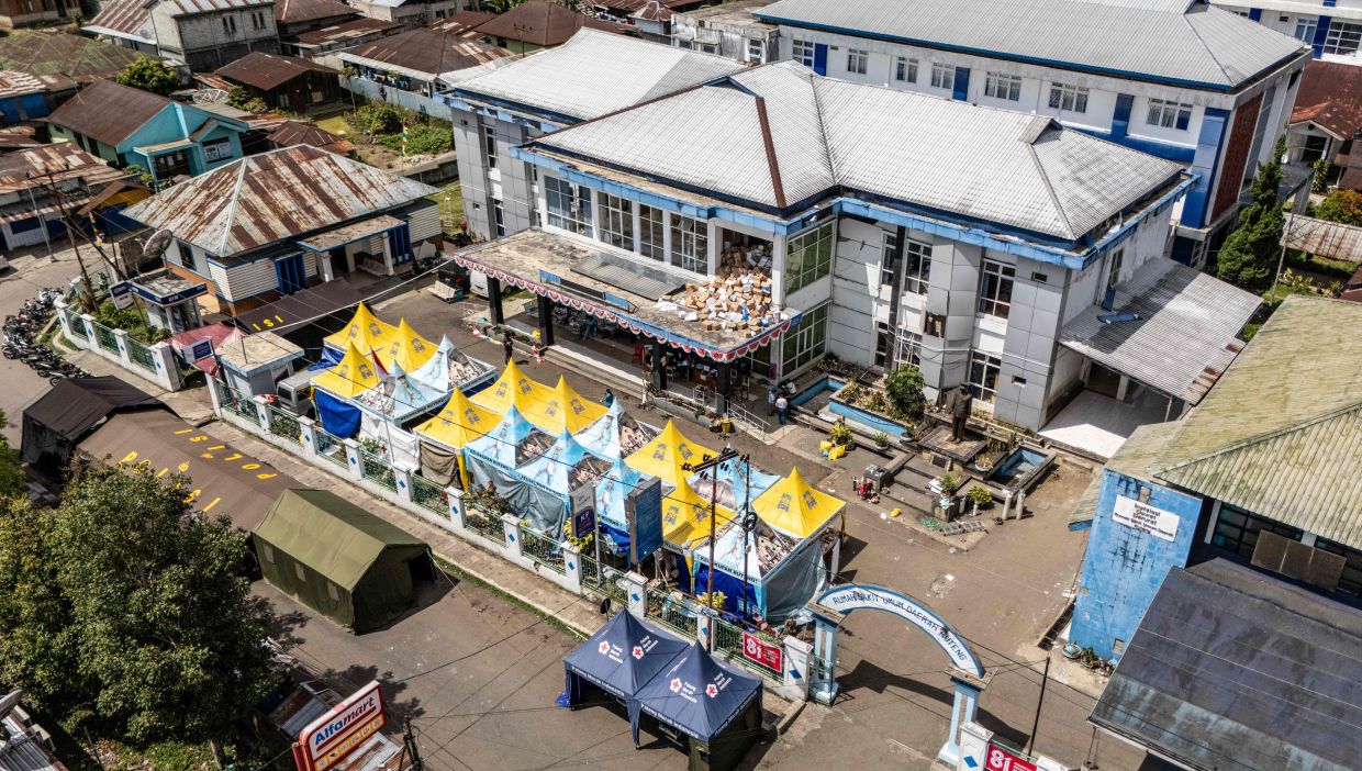 This aerial photo shows temporary medical tents set up next to the damaged Ruteng hospital following the 7.7-magnitude earthquake. - AFP