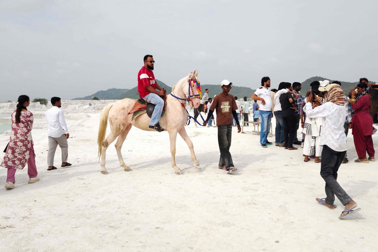 A tourist riding a horse at the yard. — AFP