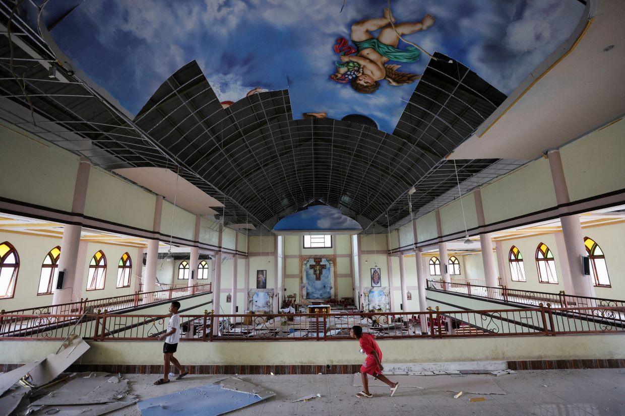 Children observe the damage at the St. Fransiskus Asisi-Karot church in the aftermath of an earthquake, in Ruteng, Manggarai regency, East Nusa Tenggara province, Indonesia, on Monday, August 17, 2026. -- REUTERS/Willy Kurniawan