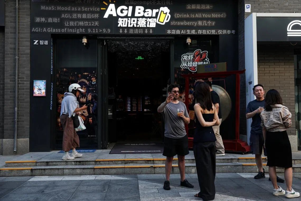 Customers chat in front of the AI-themed bar AGI Bar in Beijing’s high-tech neighbourhood of Zhongguancun. -- PHOTO: REUTERS