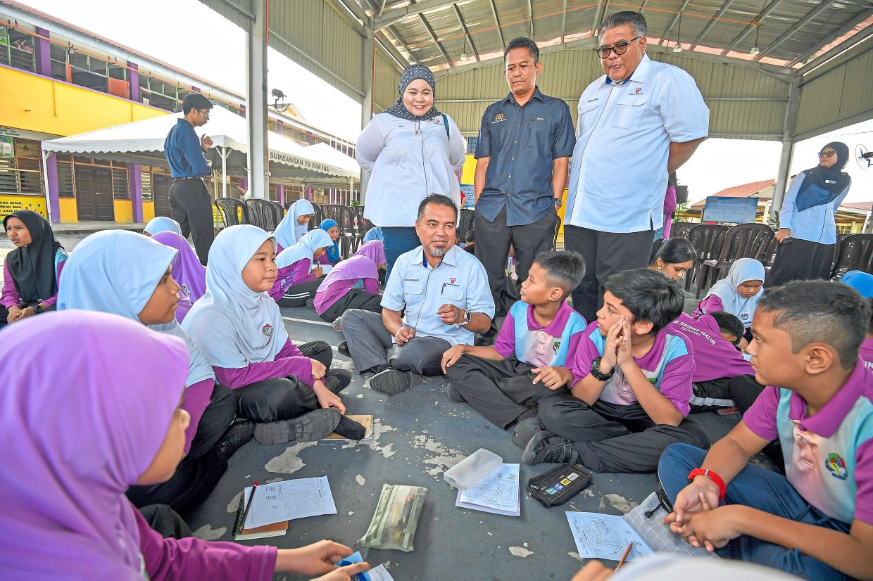Mohd Suhairi (seated, centre) interacting with students during the activities.