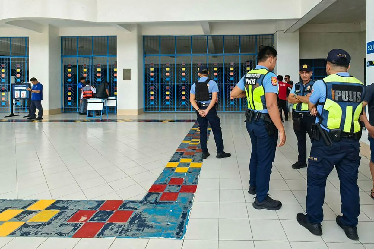 Philippine police gather at a school following a shooting in Zamboanga on August 18, 2026. A student was shot dead at a high school in the southern Philippines on August 18 before the alleged killer took his own life, police said. (Photo by Roel Parreno / AFP)