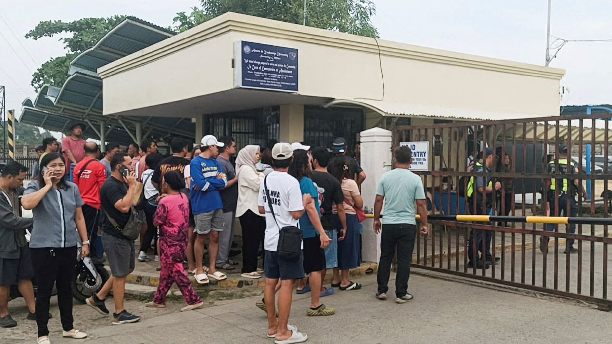 People stand outside Ateneo de Zamboanga University after a shooting that killed two people, in Zamboanga, southern Philippines, Aug18, 2026. - Photo: Reuters