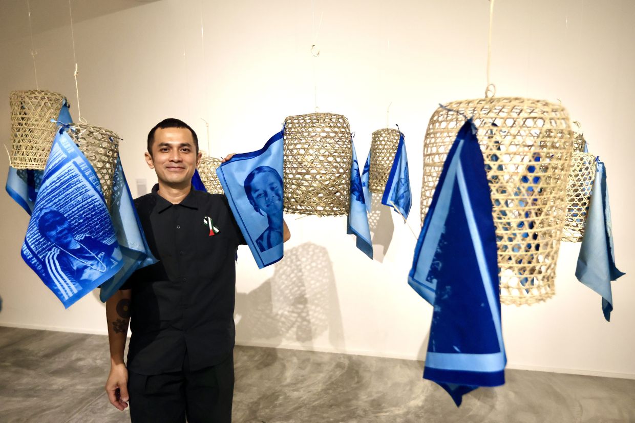 Saiful Razman with the installation piece ‘Jiwa Raga’, made from bamboo/rattan baskets affixed with cyanotype-printed portraits of Pos Jernang residents.