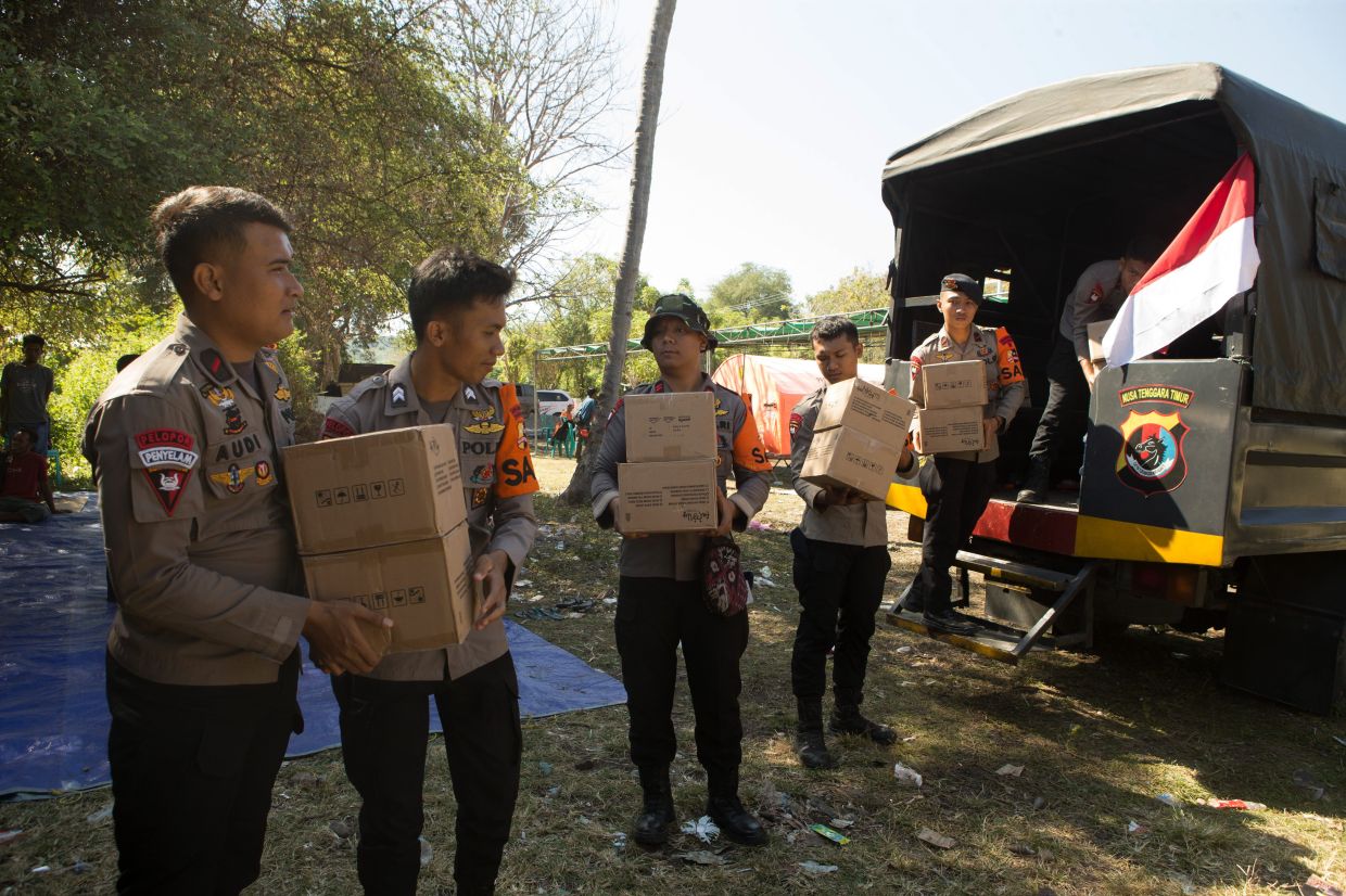 Police officers unload relief goods for earthquake survivors in North Lamba Leda, East Nusa Tenggara province, Indonesia, on Tuesday, Aug 18, 2026. -- AP Photo/Firdia Lisnawati