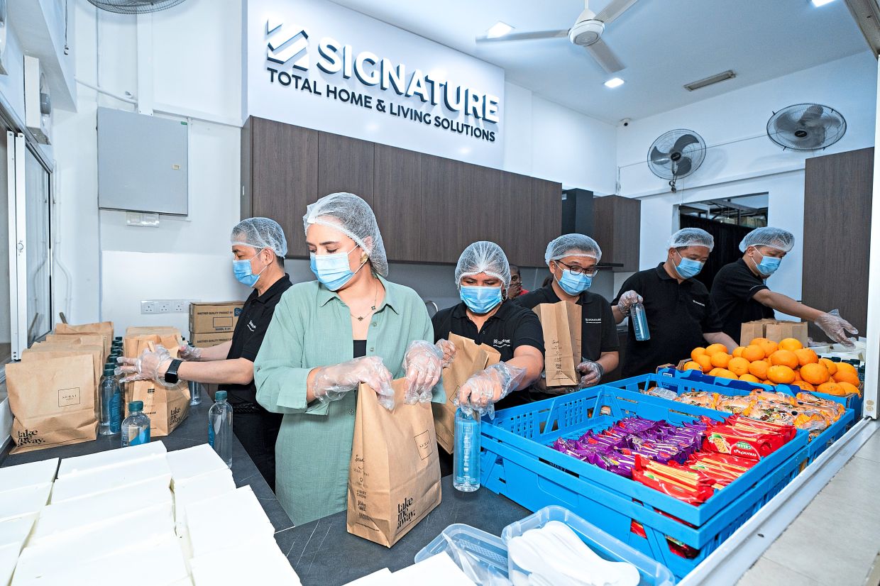 Diana (second from left) and Signature staff lending a hand at the new soup kitchen. — Handout
