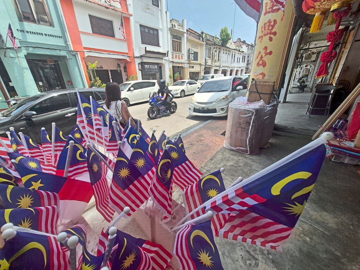 Smaller handheld Jalur Gemilang and state flags for sale in Jonker Walk.