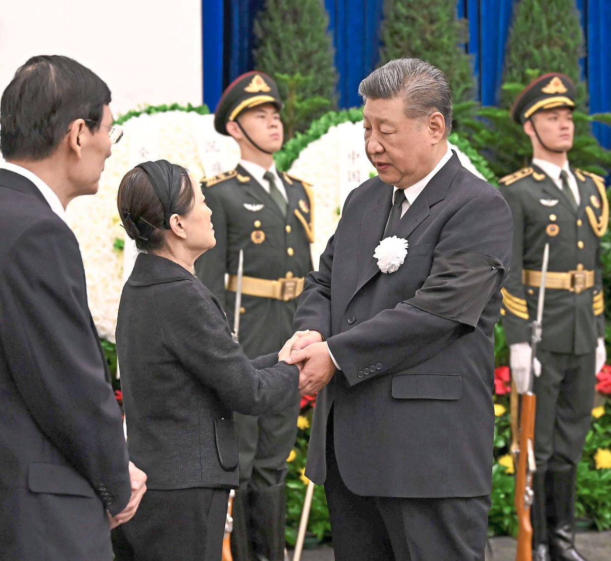 A solemn farewell: Xi shaking hands with a relative of Zhu as he pays his respects in Beijing. — Xinhua 