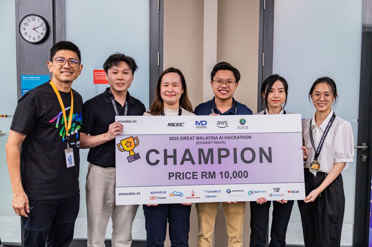 (From left) APU’s Team ‘Ctrl + Chill’ receives the mock cheque from AWS Malaysia country manager Hussein Mohd Ali. The team, comprising Cheng Kar Meng (team lead), Charlotte Chen Zi Shan, Richard Ong Tze Xin, Samantha Tee Ker Xin and Ong Ying Xin, emerged as Champion of the Great Malaysia AI Hackathon 2025 with their winning project, ‘MySelamat’.