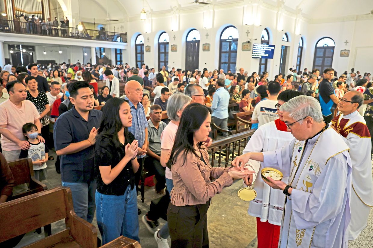 Parishioners receiving Holy Communion from a priest at the Church of the Assumption.