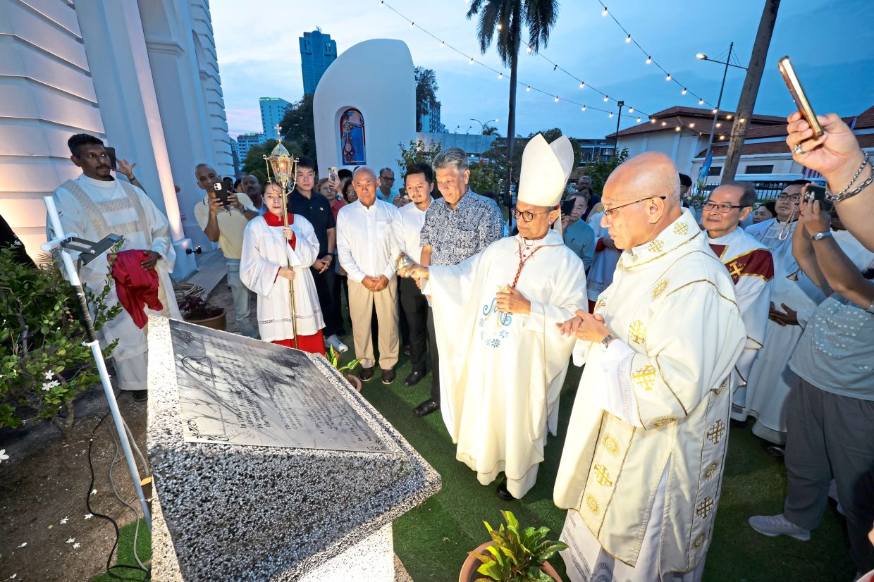 Cardinal Sebastian (wearing mitre), is joined by Penang Eurasian Association vice-president Philip Theseira (in grey shirt) and clergy members in unveiling a plaque marking the contributions of the Eurasian community.