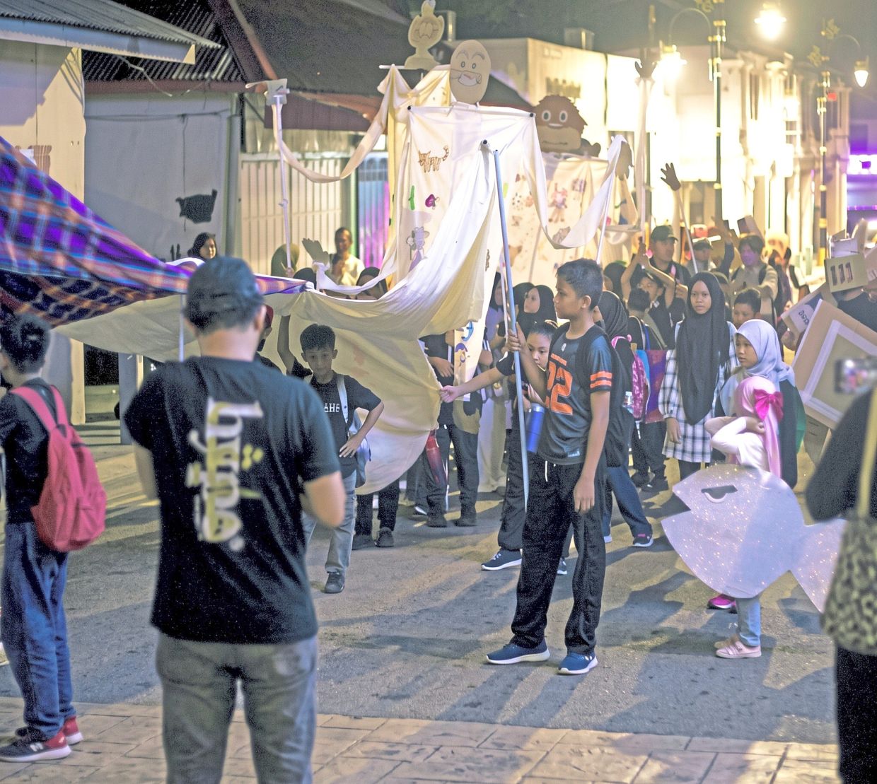 Young performers including children marching to Jalan Dato Onn to take part in a theatre performance for the public during a ‘Dive Into Bando JB: Seni Bersiri’ event in Johor Baru on Aug 15. – Courtesy photo
