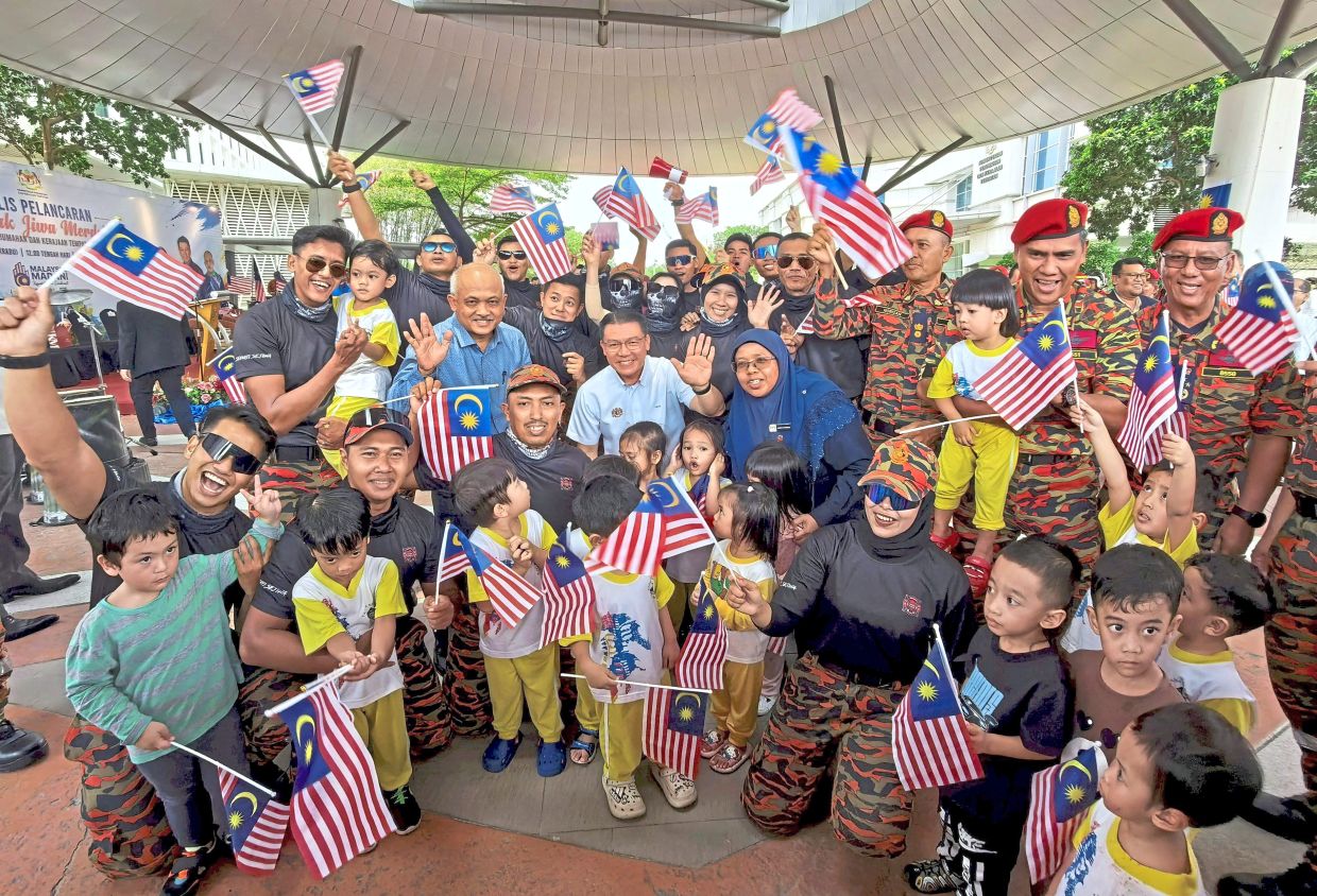 Patriotic spirit: Nga sharing a vibrant moment with ministry staff at the launch of the Semarak Jiwa Merdeka event at the Housing and Local Government Ministry. He is flanked by his deputy Datuk Aiman Athirah Sabu and ministry’s secretary-general Datuk Dr M Noor Azman Taib. — Bernama