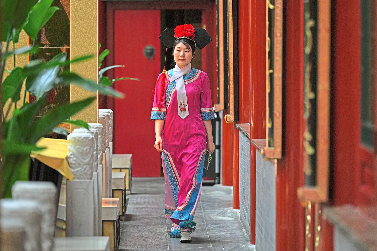 A waitress dressed in Qing Dynasty attire, in keeping with the imperial cuisine her restaurant serves.