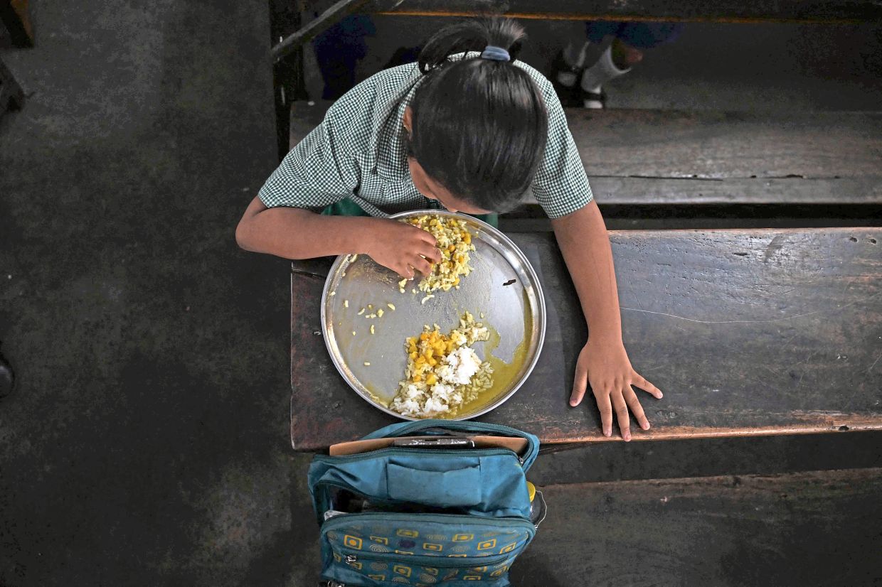 A pupil eating the mid-day meal at a government primary school in Kolkata. — AFP