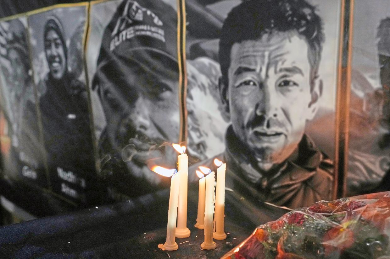 Candles burn next to pictures of the 10 climbers who lost their lives on Broad Peak during a candlelight vigil in their memory, in Islamabad, Pakistan. — AP