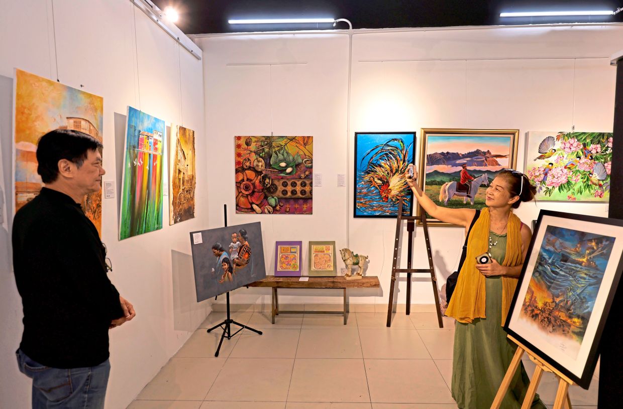 Artist Lim Eng Seong (left) posing for a photograph with his artwork.