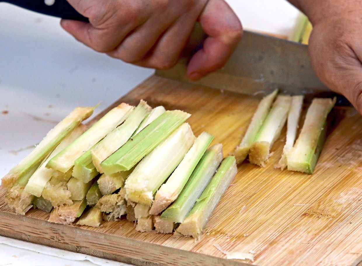 Peel off skin, then slit sugarcane into rods and cut into short sticks of about 10cm.