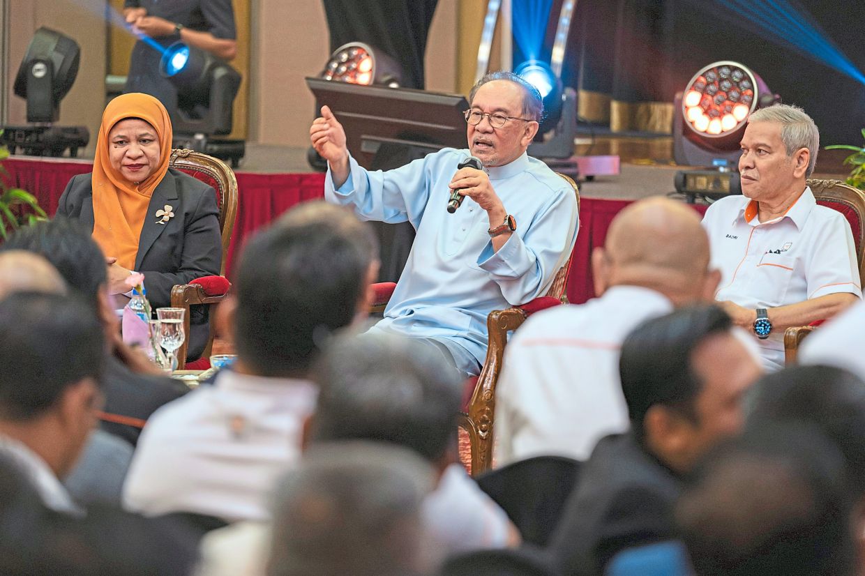 Interactive session: Anwar answering questions during a meet-and-greet event with media managers in Bangi. Looking on are Ahmad Badri (right) and Suzana Idayu (left). — Bernama