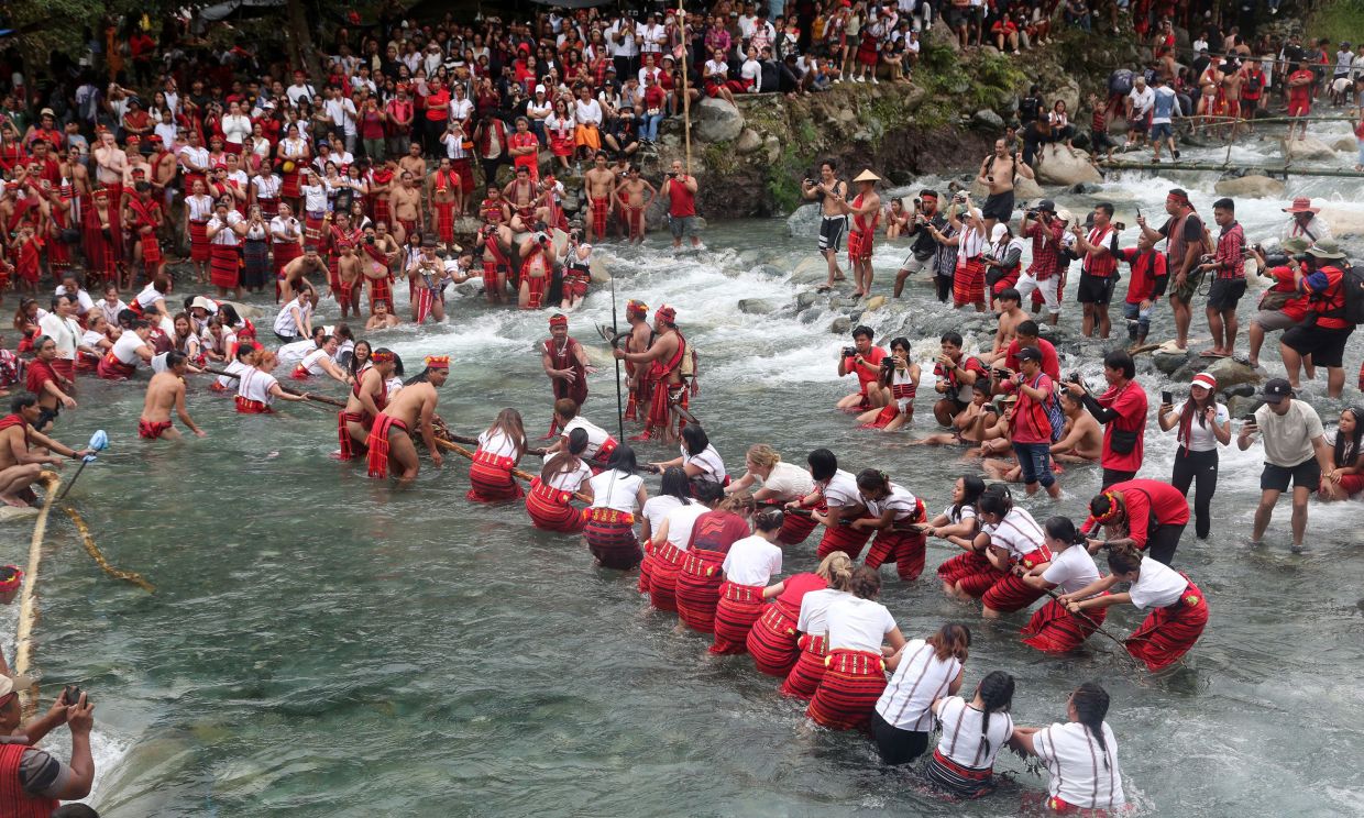 Villagers participate in a tug-of-war as they celebrate the end of the agricultural cycle called Punnuk along the Hapao River in Hungduan, Ifugao province, northern Philippines, on Saturday, Aug. 22, 2026. -- AP Photo/Harley Palangchao