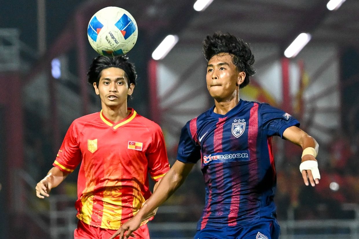 A tussle for the ball between Johor’s Adam Hakimi Mohd Zaki (right) and Selangor’s Rohisham Haiqal Hashim in the football final at Malaysia Games (Sukma). — IZZRAFIQ ALIAS/The Star