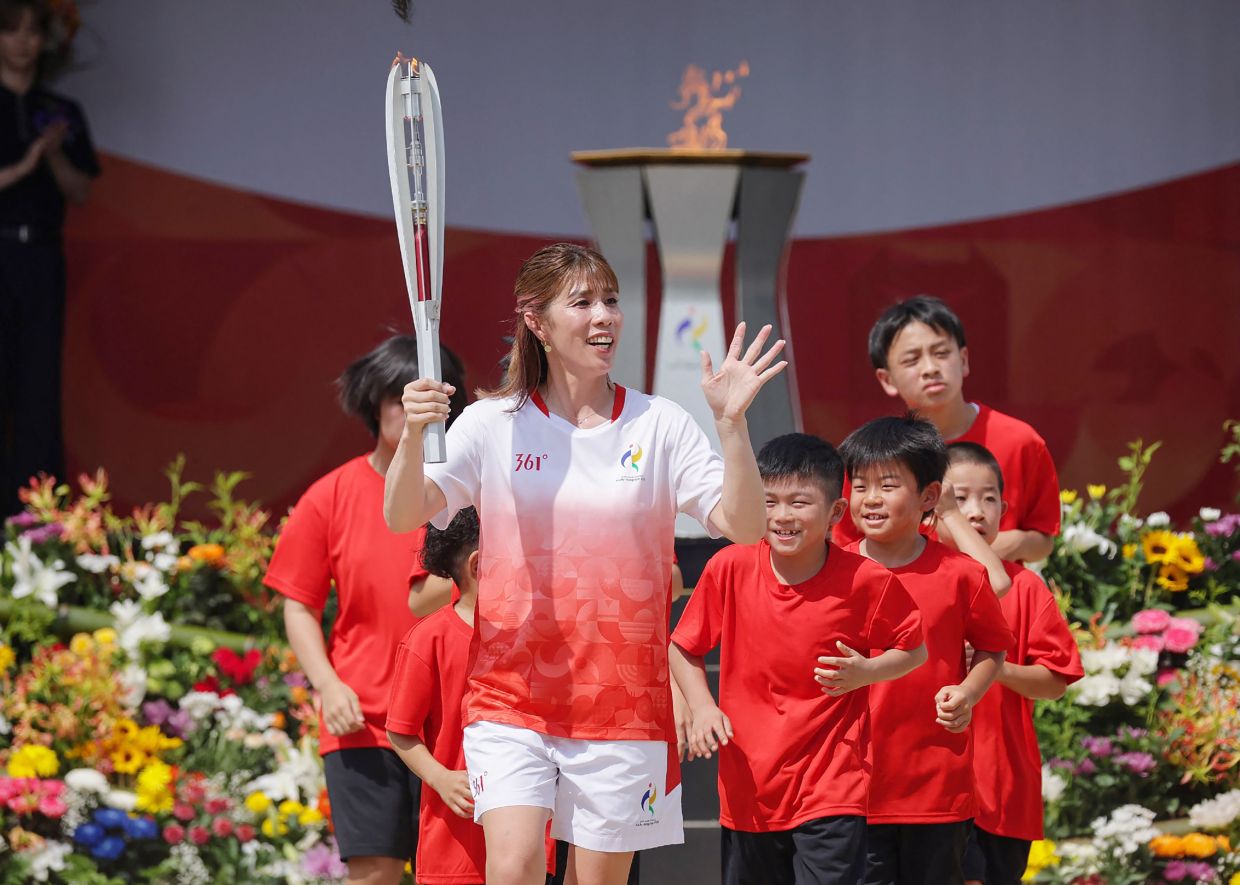Japanese three-time Olympic wrestling gold medalist Saori Yoshida serves as the first torchbearer in the Aichi-Nagoya Asian Games torch relay in Nagoya city on Saturday, August 22, 2026 -- Photo by JIJI Press / AFP 