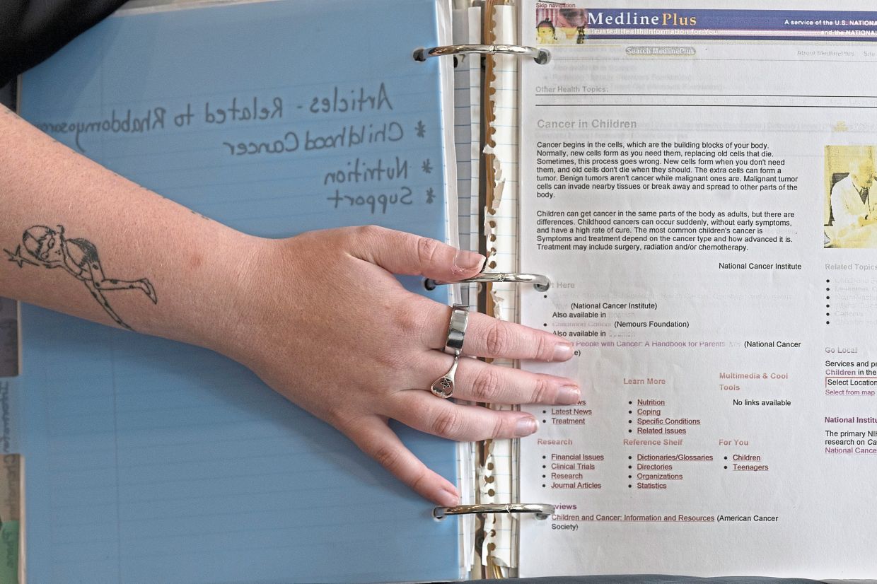 Walz looks through documents her family archived in a binder during her cancer treatment at Children’s Hospital of Philadelphia.