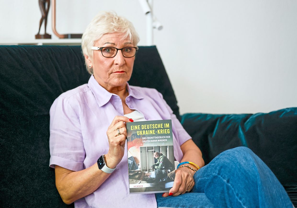 Ula holding the published diary of her daughter.
