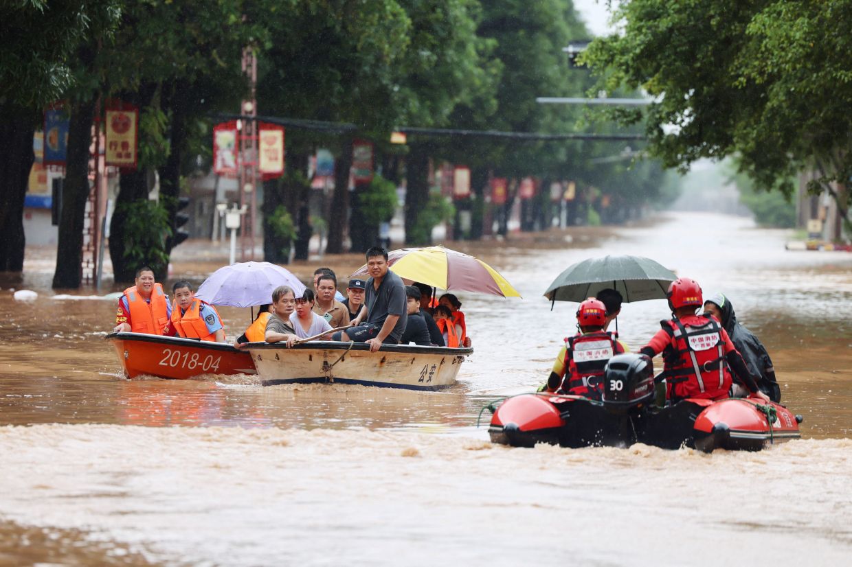 Rescue workers evacuate flood-affected residents by boat after heavy rainfall brought by Typhoon Narra caused flooding in Ningming County, Chongzuo, Guangxi Zhuang Autonomous Region, China, August 23, 2026. -- cnsphoto via REUTERS