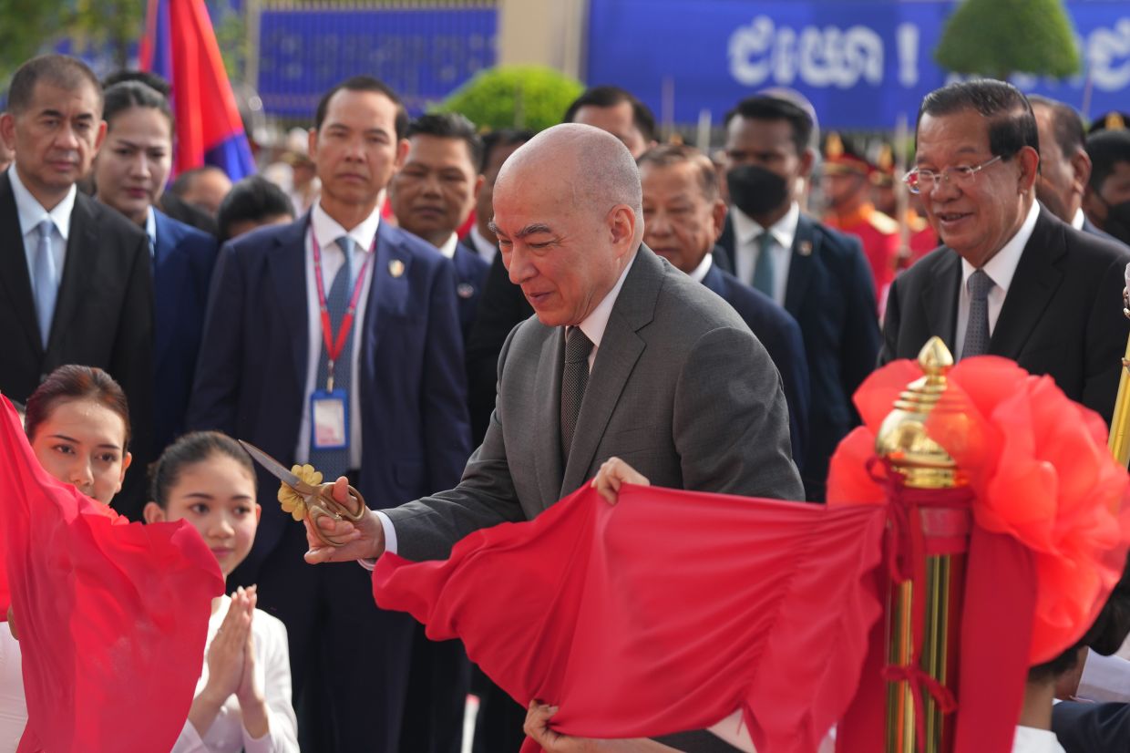 Cambodia's King Norodom Sihamoni cuts a ribbon as he presides over an inauguration at the Solidarity Palace of Senate in Phnom Penh, Cambodia. -- AP Photo/Heng Sinith