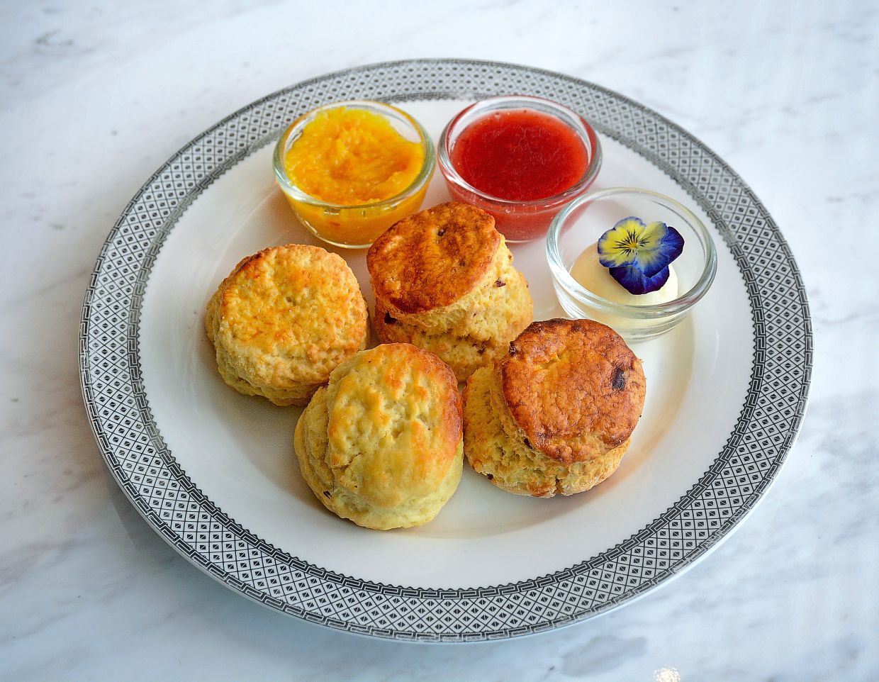Cranberry and Vanilla Scones served with orange marmalade, strawberry jam and clotted cream bring a British touch to the table. 