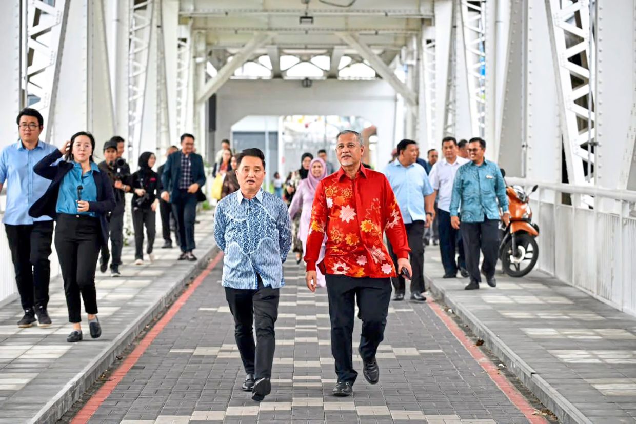Ng (left) taking a stroll with Abd Hamid on Jambatan Kota, checking out the Saturday market at Klang’s latest tourist attraction. — Courtesy of MBDK