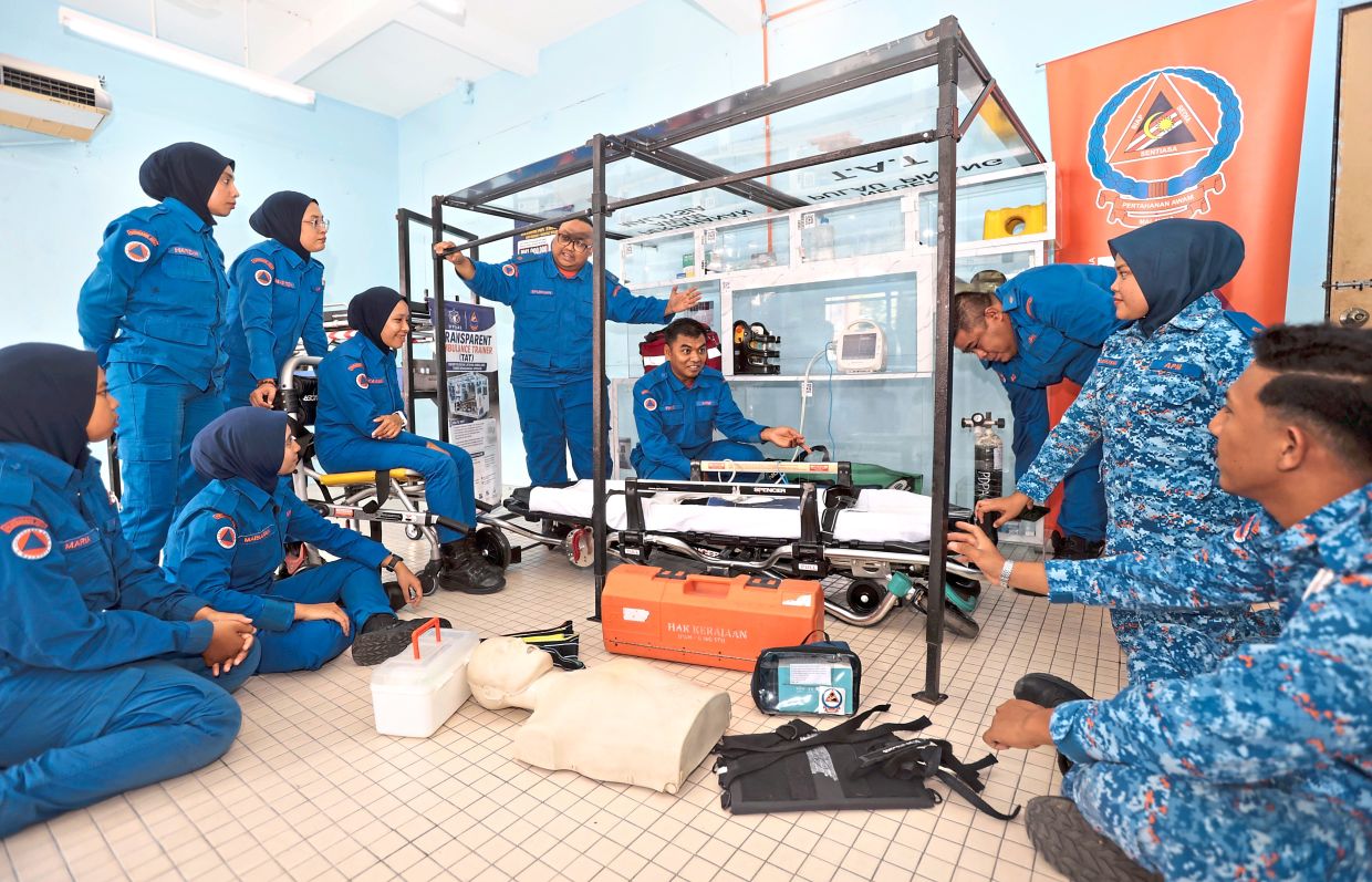 Watch and learn: Lt Syukran Ahmad (centre, standing) explaining the TAT mechanism to APM officers and personnel. — ZHAFARAN NASIB/The Star