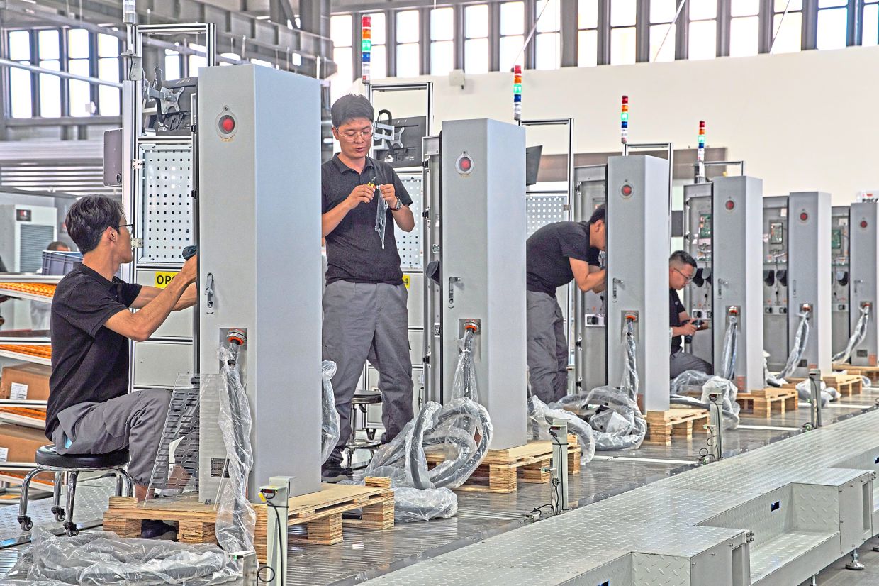 Workers assembling charging stations in Inner Mongolia province. — AP