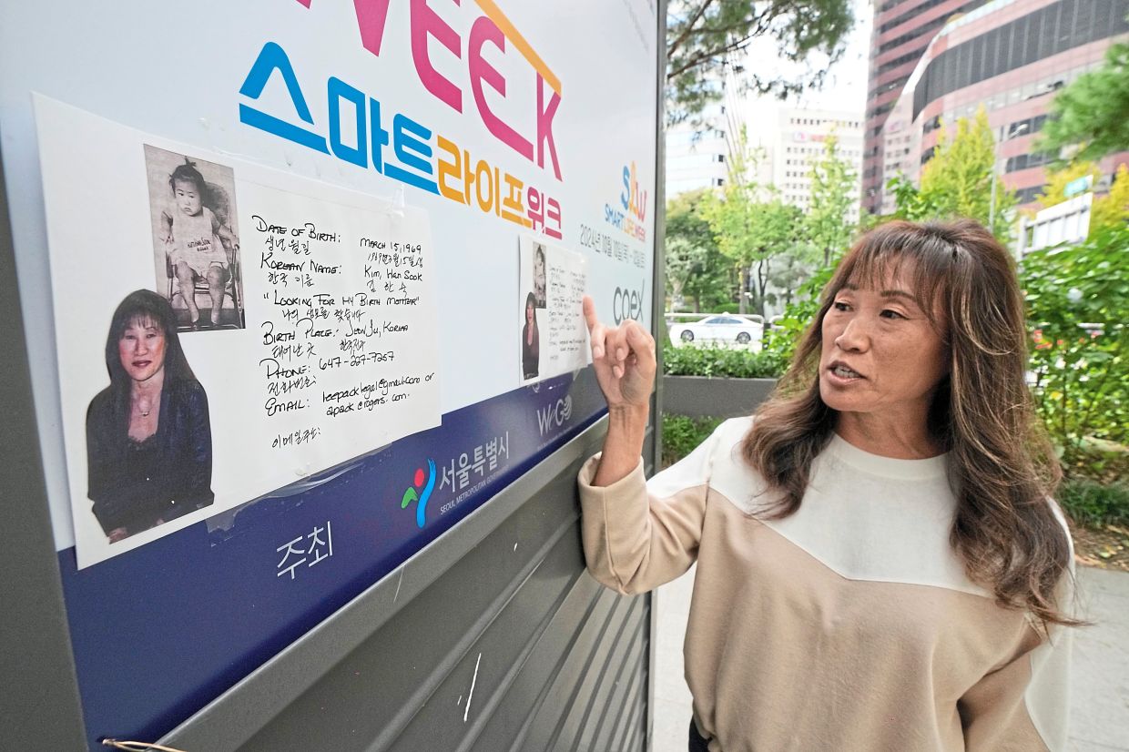 Lee-Pack showing flyers with her photos attached to a newspaper stand on a street in Seoul.