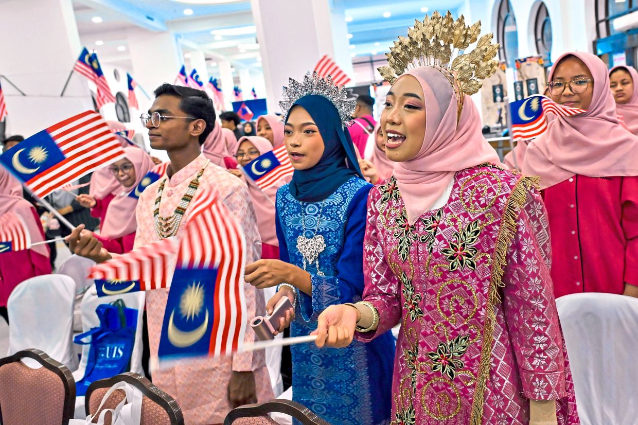 Students taking part in the ‘Kembara Bahasa Hari Kebangsaan dan Hari Malaysia 2026’ waving the Jalur Gemilang at the starting point of the journey at the Kuala Lumpur Railway station.
