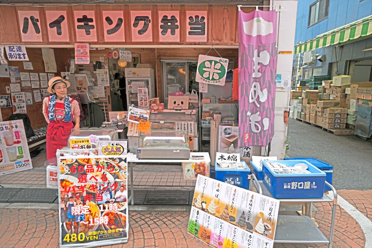 Akiko Sugaya waits for customers at her takeout lunch shop, which turns into a dine-in restaurant in the evening.