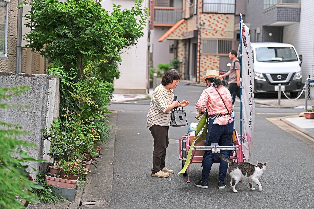 Sugaya (right) sells her items to her regular customer.