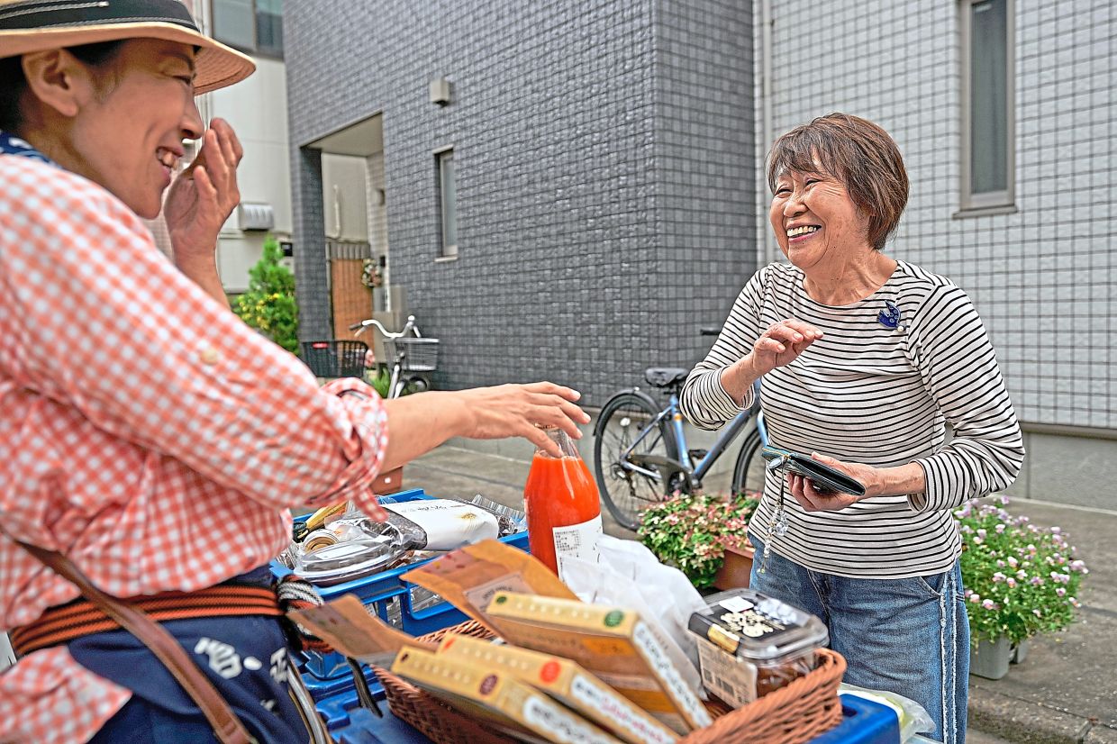Sugaya (left) chats with her regular customer buying her items.
