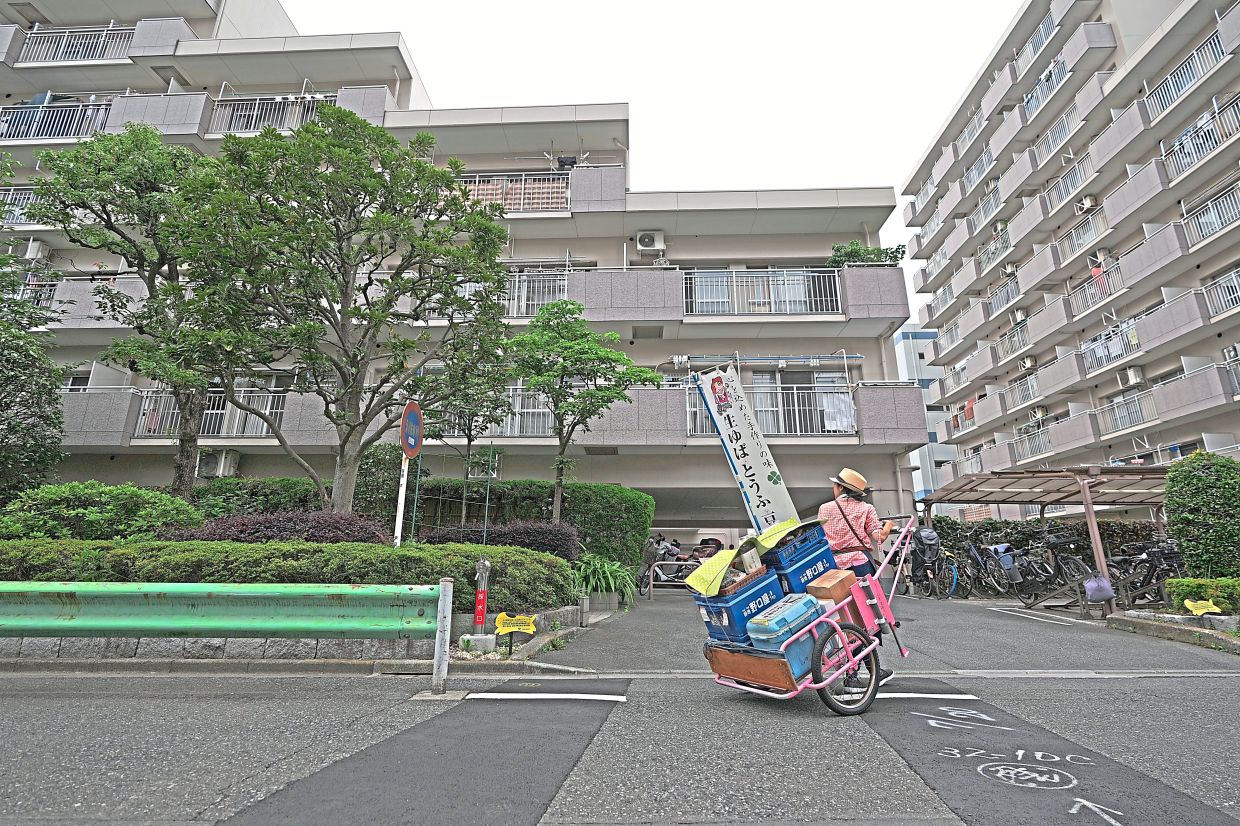 Sugaya looks for signs of customers while she peddles tofu, prepared food and beverages in a cart.