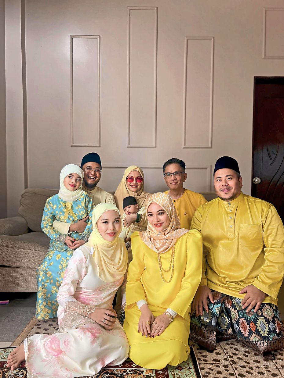 Maslinda (back, third from left) with her family, who have watched her journey from banking and beauty to fitness and Pilates.