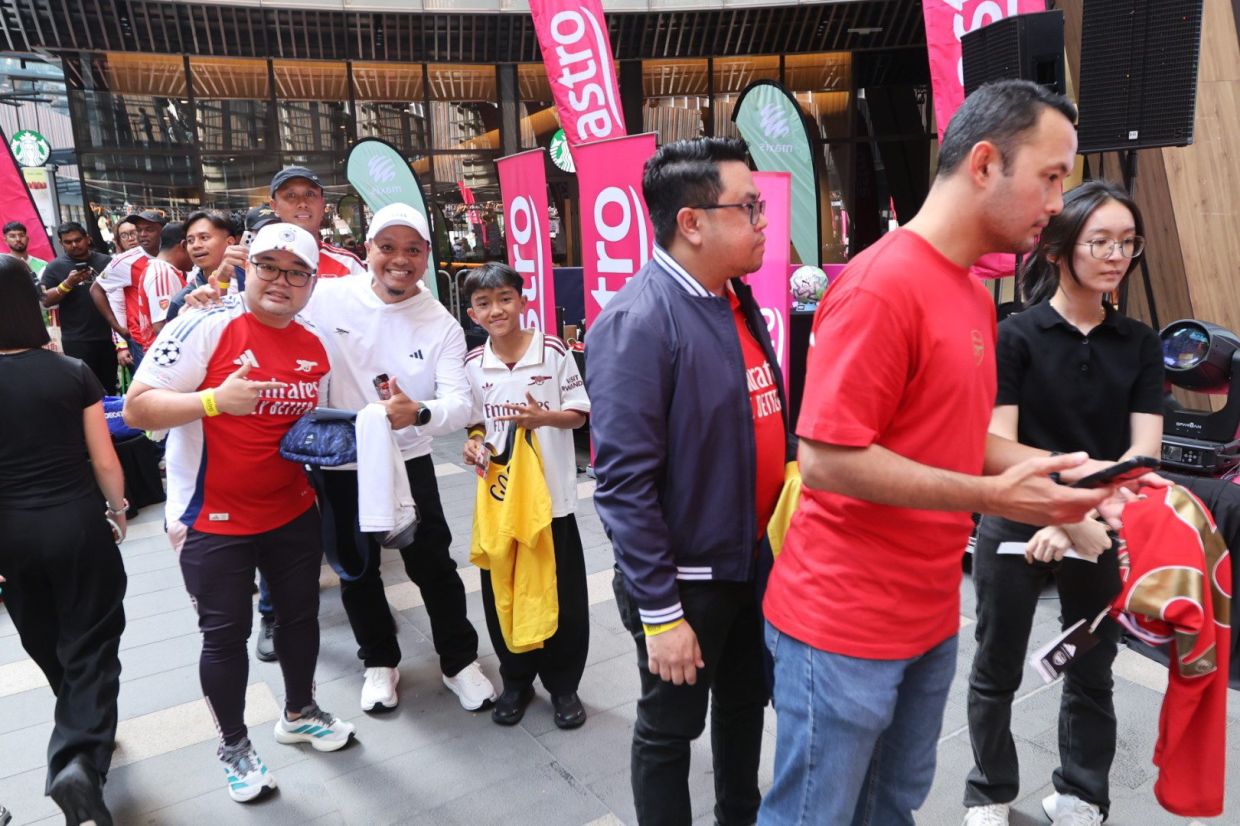 Excited Arsenal FC fans lining up for their photo op with Seaman.
