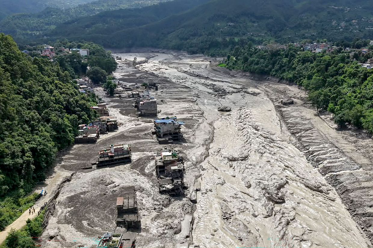 Houses lie partially submerged in muddy water along a riverside after flash floods at Trishuli Bazar in Nepal's Nuwakot district on Aug 26, 2026. A massive flood swept through Nepal's northern Rasuwa district on Aug 26, damaging roads and power infrastructure as authorities scrambled to assess the scale of the destruction. - Photo: AFP