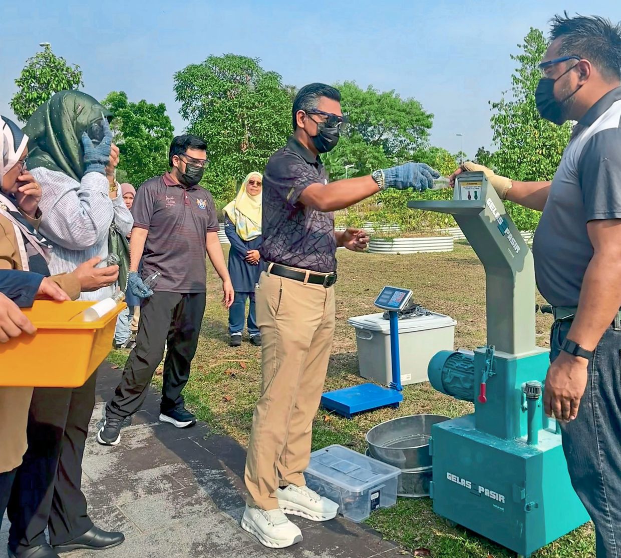 Participants being shown how to operate the glass crushing machine at Edible Park in Medini, Iskandar Puteri.Left: The output from the glass crushing machine − glass sand (right) and granules (left) − that can be mixed with other elements to produce various products.