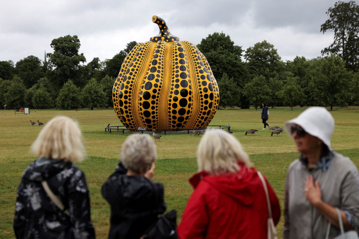People look at Yayoi Kusama's sculpture 'Pumpkin' in Kensington Palace Gardens in London in July 2024. Photo: Reuters 